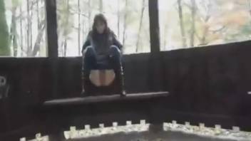 Young woman defecating on a park bench